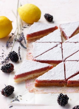 Blackberry Lavender Lemon Bars cut into triangles and dusted with sugar
