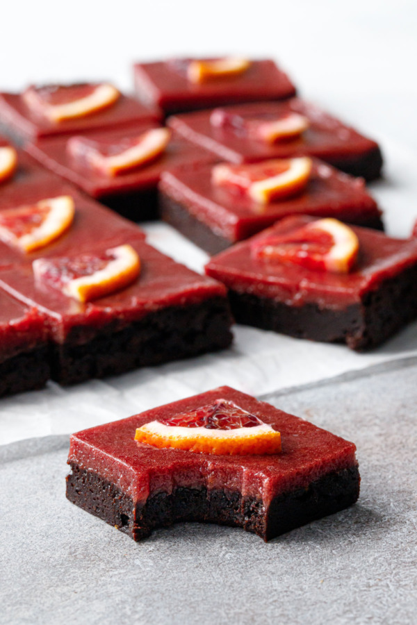 Blood Orange Curd Brownies cut into squares, the one in front with a perfect bite taken out of it.
