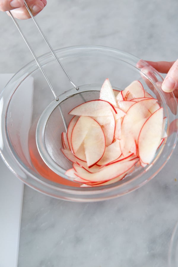 Soaking thinly sliced apple in a brine to soften and keep from browning.