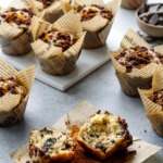 Chocolate Orange Streusel Muffins on a gray background, one muffin broken in half to show the fluffy interior texture.