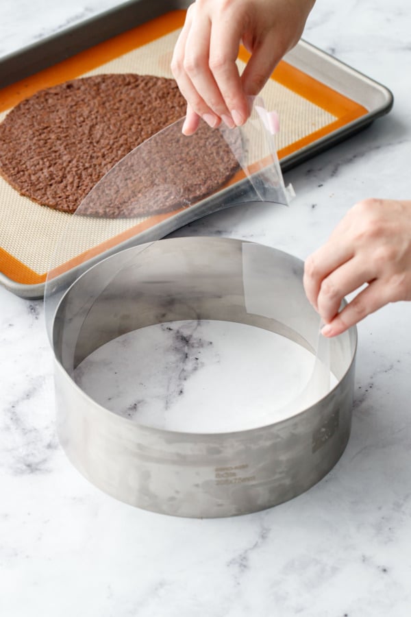 Lining a metal cake ring with a strip of clear acetate.
