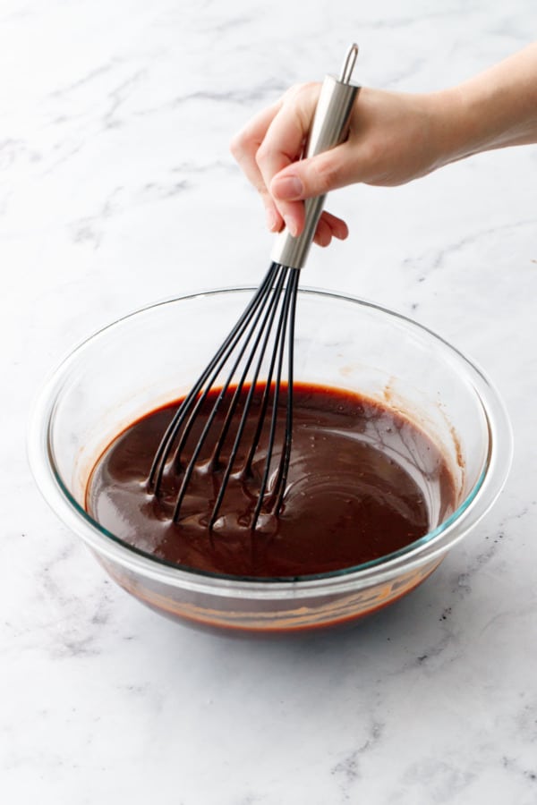 Gently whisking until the chocolate is melted and the glaze is silky smooth and shiny.