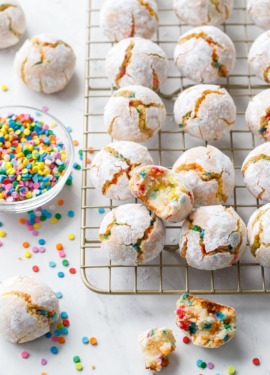 Messy arrangement of funfetti amaretti cookies with broken and bitten into cookies to show texture