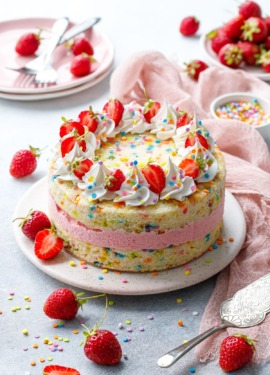 Strawberry Funfetti Ice Cream Cake on gray with pink linen and fresh berries