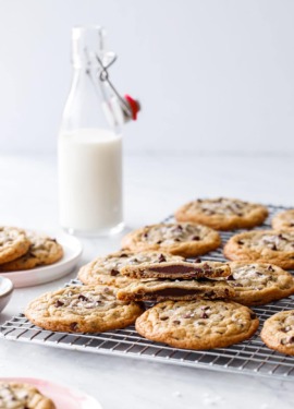 Ganache-Stuffed Chocolate Chip Cookies on a wire rack with a glass milk bottle