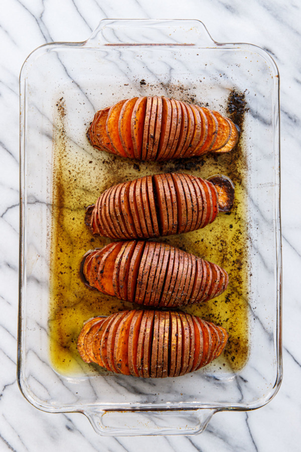 Spiced Hasselback Sweet Potatoes in a glass casserole dish, after baking
