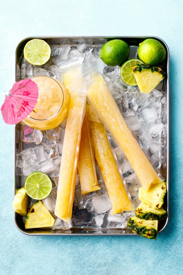 Overhead, Frozen Mai Tai Slushy Pops on a metal tray with a cocktail glass and pink umbrella.
