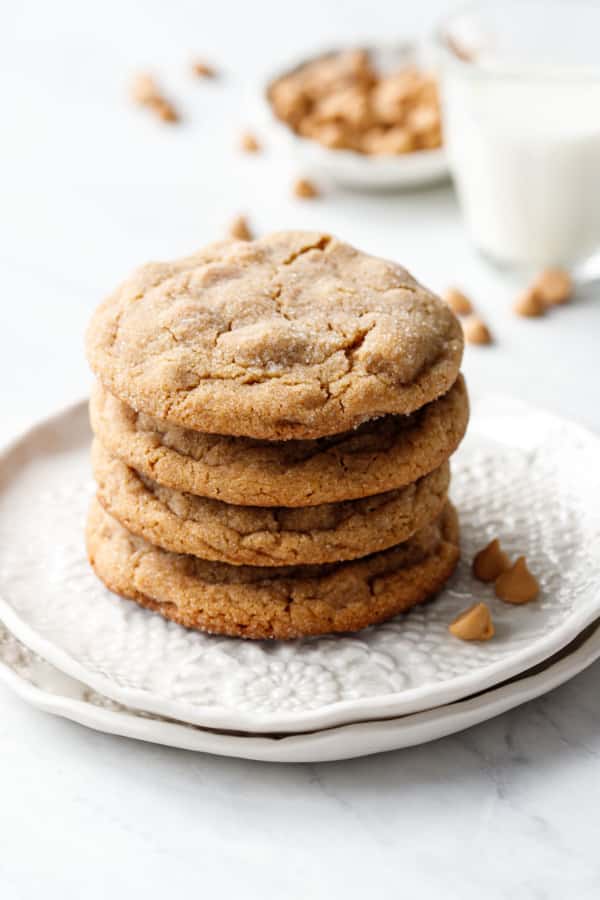 Stack of four Salted Peanut Butter Chip Cookies on a white lace ceramic plate.