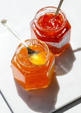 Bright sunlight making the red and orange pepper jelly sparkle