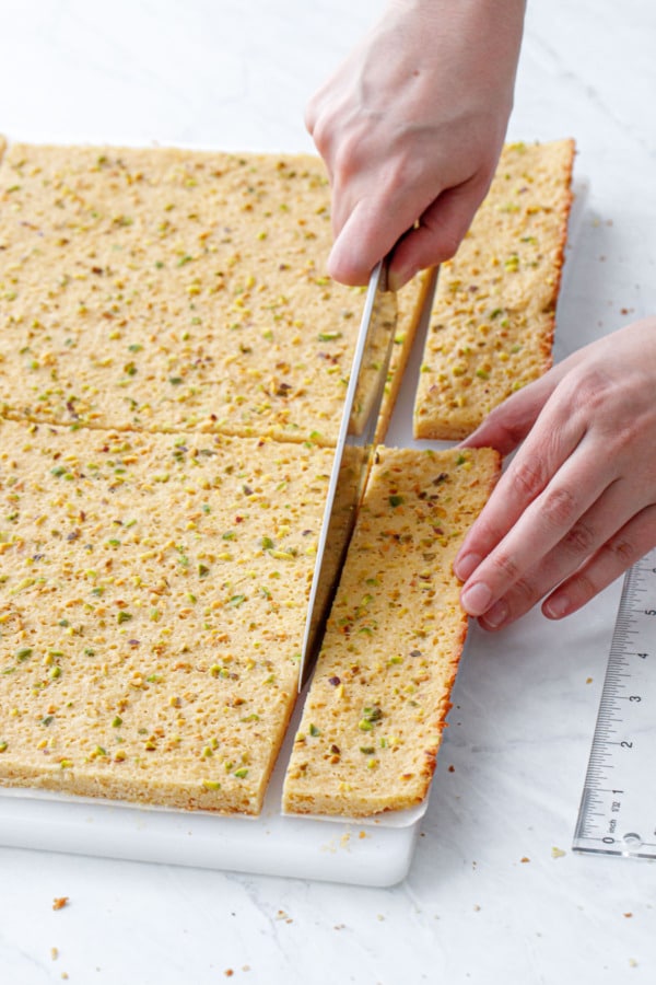 Cutting the cooked blondie layer into two even 8-by-8-inch squares.