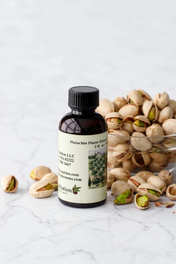 Olive Nation Pistachio Extract bottle with bowl of pistachios.