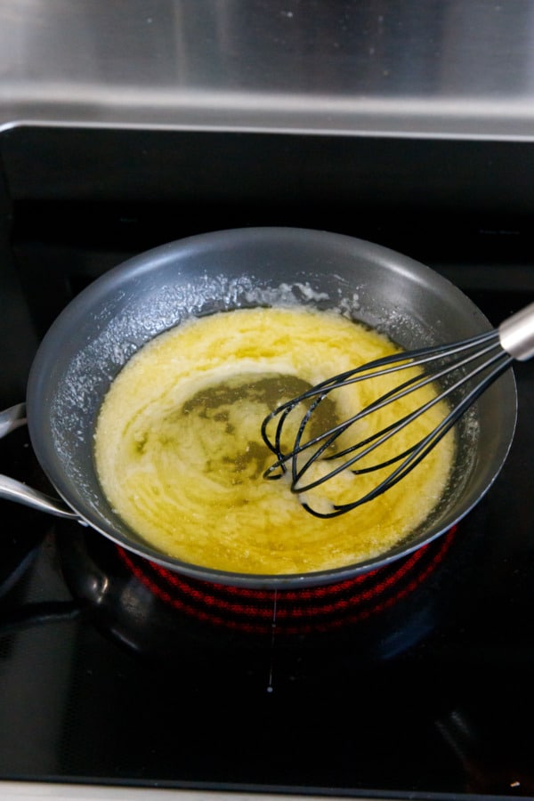 Whisking melted butter and sugar in a skillet, the mixture appears greasy and separated at first.
