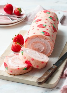 Two slices of a strawberry cake roll, showing the spiral shape and whipped cream filling.